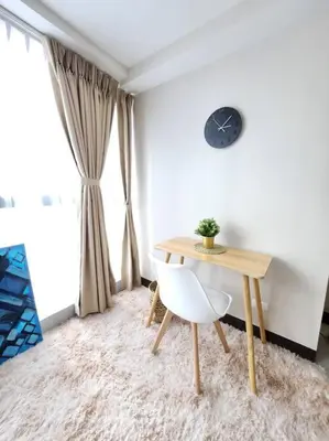 a table and a chair in a room with a clock at Cosy Executive 1 BR Uptown Parksuites Ultra fast Internet in Manila