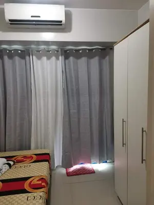 a bedroom with a window with scissors on it at Sea Residences Staycation Tanya's Condo Pasay in Manila