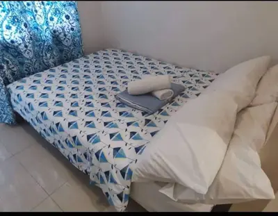a bed with a blue and white comforter on it at Sea Residences Staycation by TVANS CONDOTEL Pasay City in Manila