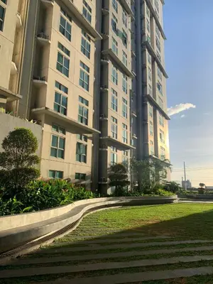 a large apartment building with a lawn in front of it at SLP Montecillo in Manila