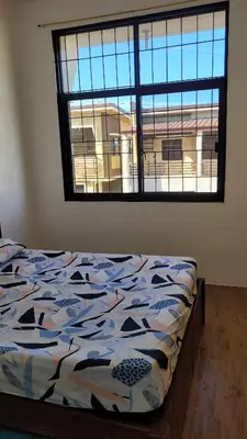 a bed in a room with a large window at Camilyn Home Stay in General Trias