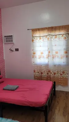 a bedroom with a red bed with a window at Camilyn Home Stay in General Trias