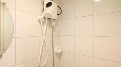 a shower in a bathroom with a phone on the wall at Yuzons Bedspacer and Transient Home Staycation in Manila