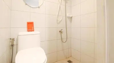 a white bathroom with a shower with a toilet at Yuzons Bedspacer and Transient Home Staycation in Manila