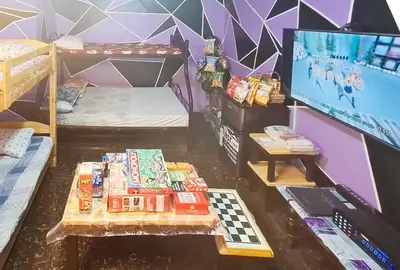 a room with a tv and a table with snacks at Yuzons Bedspacer and Transient Home Staycation in Manila