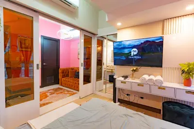 a bedroom with a tv and a bed in a room at Modern 1BR in Uptown BGC in Manila