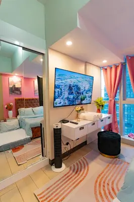 a living room with a large tv on the wall at Modern 1BR in Uptown BGC in Manila