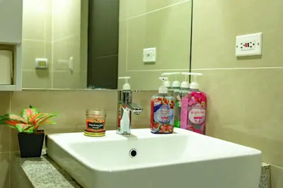 a white sink in a bathroom with a mirror at Modern 1BR in Uptown BGC in Manila