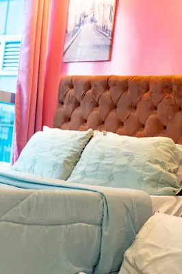 a bed with a brown headboard and pillows at Modern 1BR in Uptown BGC in Manila