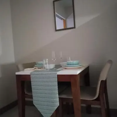 a dining room table with two chairs and a mirror at One Uptown Opposite of grandhyatt hotel manila Taguig city in Manila