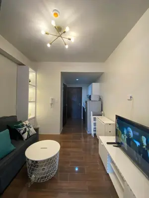 a living room with a couch and a flat screen tv at Air Residences 4439 in Manila