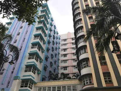 a tall building with palm trees in front of it at 101 Newport condo in Pasay near airport in Manila