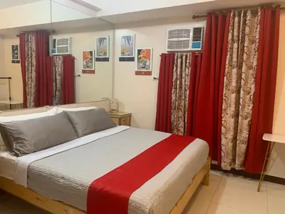 a bedroom with a bed with red curtains at 101 Newport condo in Pasay near airport in Manila