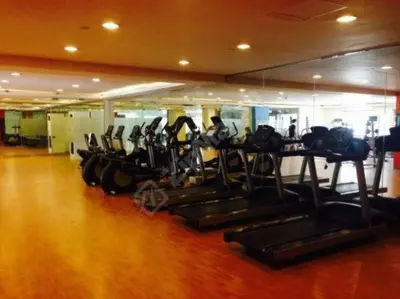 a gym with a row of tread machines in a room at Comfy Artsy Studio in BGC in Manila