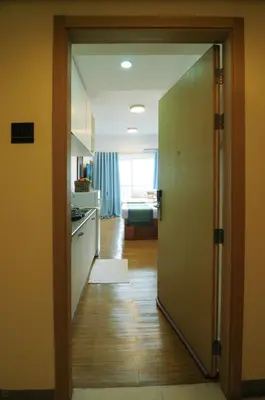 a kitchen with a door open to a kitchen with a counter at R'Holistay Grace Taguig Fast Wifi Self Check In in Manila