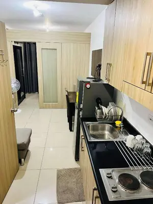 a kitchen with a sink and a stove top oven at Shore Residences MOA by darpm in Manila