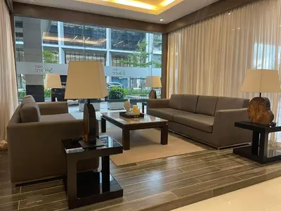 a living room with couches and tables in a building at Shore Residences MOA by darpm in Manila