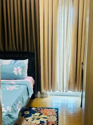 a bedroom with a bed and a window with curtains at 1BR Homy Furnished Unit Grace Residences Taguig in Manila