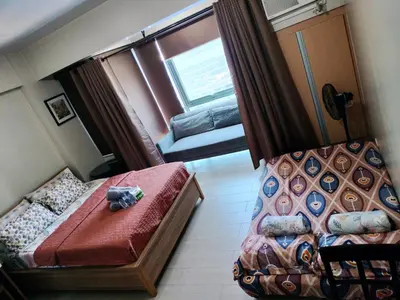 a small room with a bed and a window at Palmtree Villas Two Condotel Near Airport in Manila