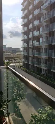 a large apartment building with a reflecting pool in front of a building at Transient Near Airport by Rqui in Manila