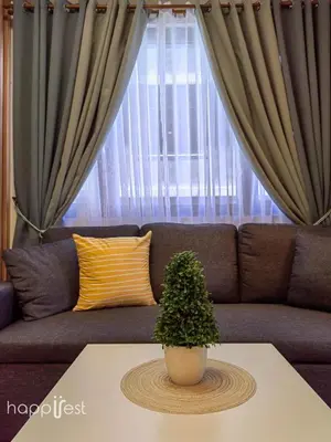 a living room with a couch with a plant on a table at Happirest at Shore 3 Residences with Balcony, Mall of Asia in Manila