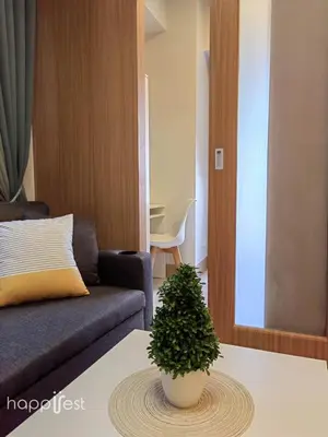 a living room with a couch and a plant on a table at Happirest at Shore 3 Residences with Balcony, Mall of Asia in Manila