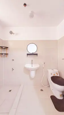 a white bathroom with a sink and a toilet at Night Blink Staycation And Rentals in Cainta