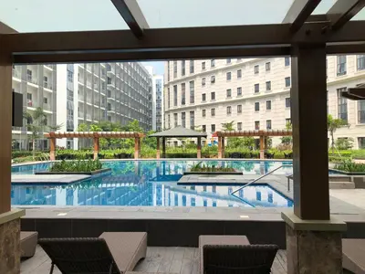 a large swimming pool with chairs and buildings at Robles’ Unit at 81 Newport Boulevard in Manila