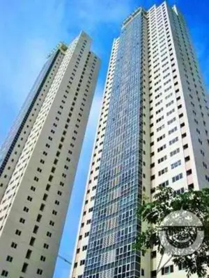 two tall buildings with a clock in front of them at BGC Private Apartments in Manila