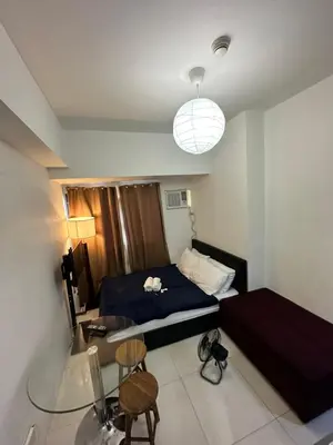 a bedroom with a bed and a table and chairs at Grand Riviera Suits in Manila