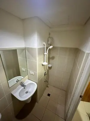 a bathroom with a sink and a shower at Grand Riviera Suits in Manila