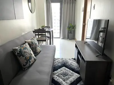 a living room with a couch and a television at Shore 3 Residences, Tower 1 Mall of Asia Complex, Pasay City, Metro Mania in Manila