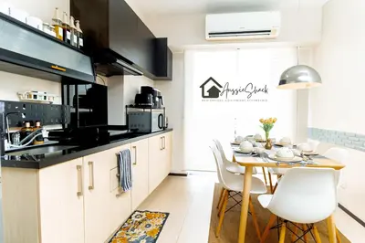 a kitchen with a table and chairs in a room at Aussie Shack - 2BR Modern Condo with Skyline View in Manila