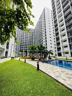 a park in front of some tall buildings at Victoria’s Place in Manila