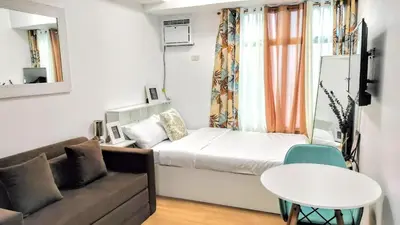 a small living room with a couch and a table at ROARI Portovita Towers Scandinavian Studio Unit in Manila