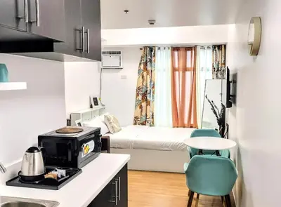 a small room with a bed and a kitchen at ROARI Portovita Towers Scandinavian Studio Unit in Manila