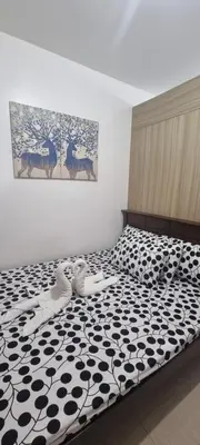 a bedroom with a bed with a black and white comforter at EZStays Shore Residences in Manila