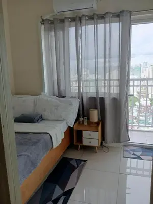 a small bedroom with a bed and a window at Breeze Residences - 1BR Unit with Balcony -Top Floor in Manila
