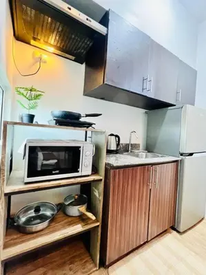 a small kitchen with a microwave and a sink at Sweet Home with WiFi and Netflix in Manila