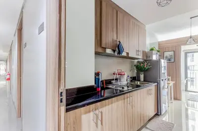 a kitchen with wooden cabinets and a refrigerator at Shore 2 Apartment with Balcony in Manila