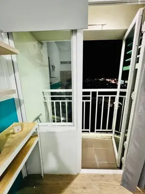 a room with a balcony with a view of the city at Cozy Place Anuva Residences in Manila