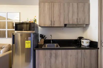 a kitchen with a stainless steel refrigerator and a sink at Luxury Sunset Views and Prime Location near CCP MOA with WIFI Parking in Manila