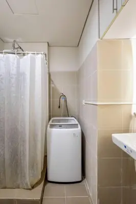 a bathroom with a white shower curtain and a toilet at Luxury Sunset Views and Prime Location near CCP MOA with WIFI Parking in Manila