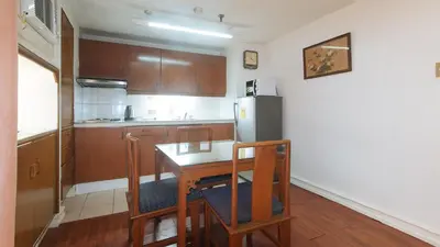 a kitchen with a table and a refrigerator at Sunette Tower Makati in Manila