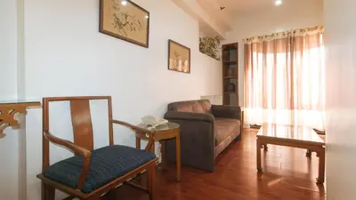 a living room with a couch and a chair at Sunette Tower Makati in Manila