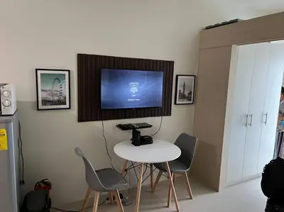 a room with a table and chairs and a tv on the wall at JAZZ Residences - 1 Bedroom with Balcony - Cable, Wifi & Netflix in Manila