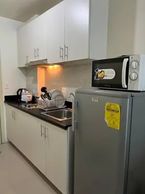a kitchen with a refrigerator and a sink and a microwave at JAZZ Residences - 1 Bedroom with Balcony - Cable, Wifi & Netflix in Manila