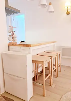 a kitchen with a white desk and stools at Azure SKYVIEW PENTHOUSE minimalist unit in Manila