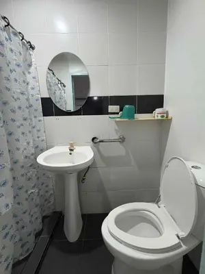 a bathroom with a toilet and a sink and a mirror at DUCK INN AND RESTAURANT in Manila