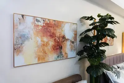 a painting hanging on a wall next to a couch at A2J Luxury Venice Studio Suite Near BGC Malls in Manila